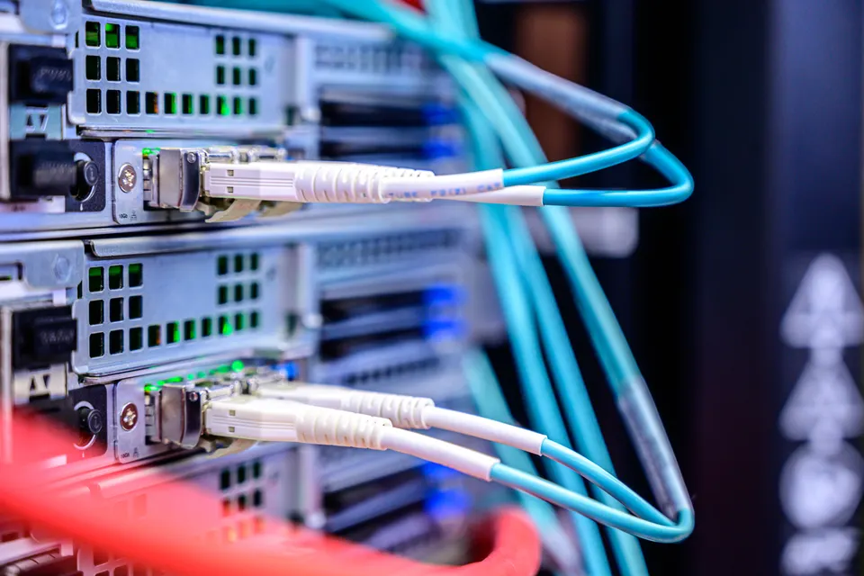 Cordons optiques bleus branchés dans des modules réseau à l’arrière de serveurs